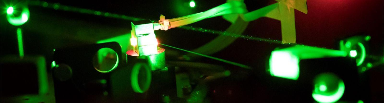 Image of equipment glowing green and red in a College of Science and Technology facility.